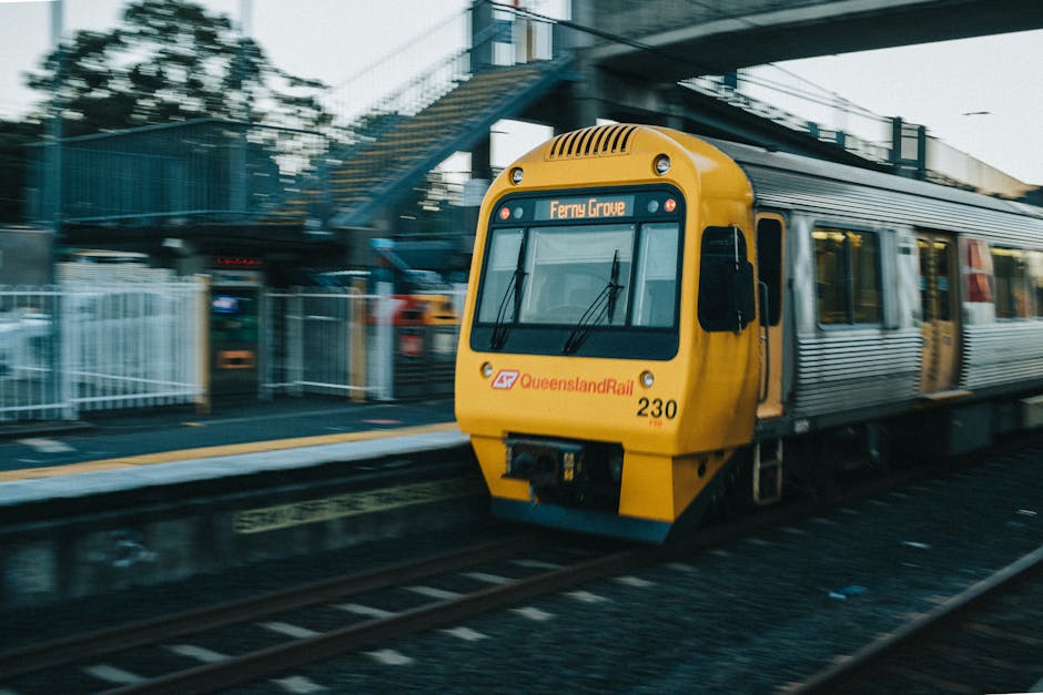 The image shows an underground train station platform with a wide, empty tiled surface and a yellow tactile paving strip along the edge for safety. The platform is illuminated by overhead fluorescent 